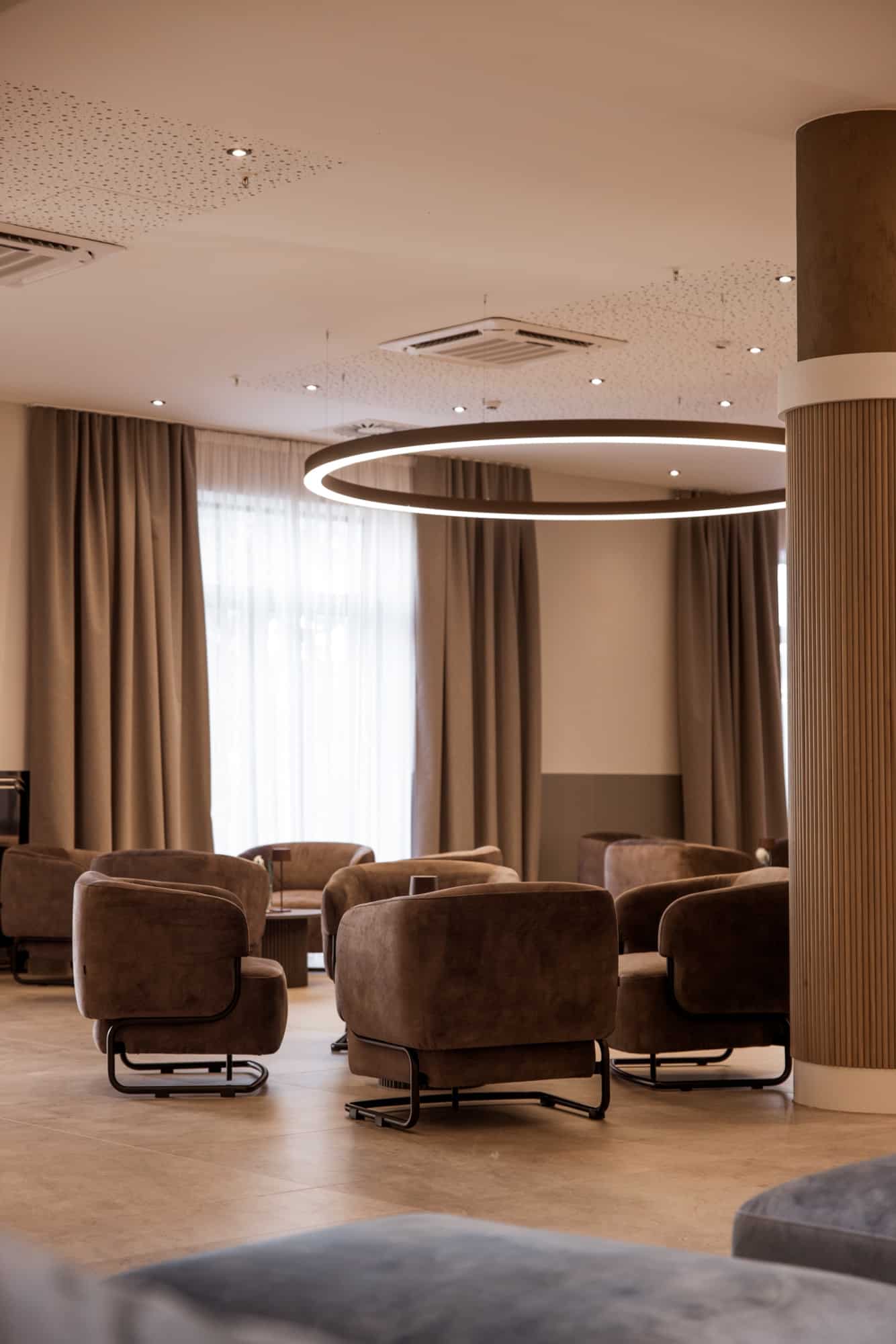 Lounge s baršunastim foteljama i kružnom rasvjetom
