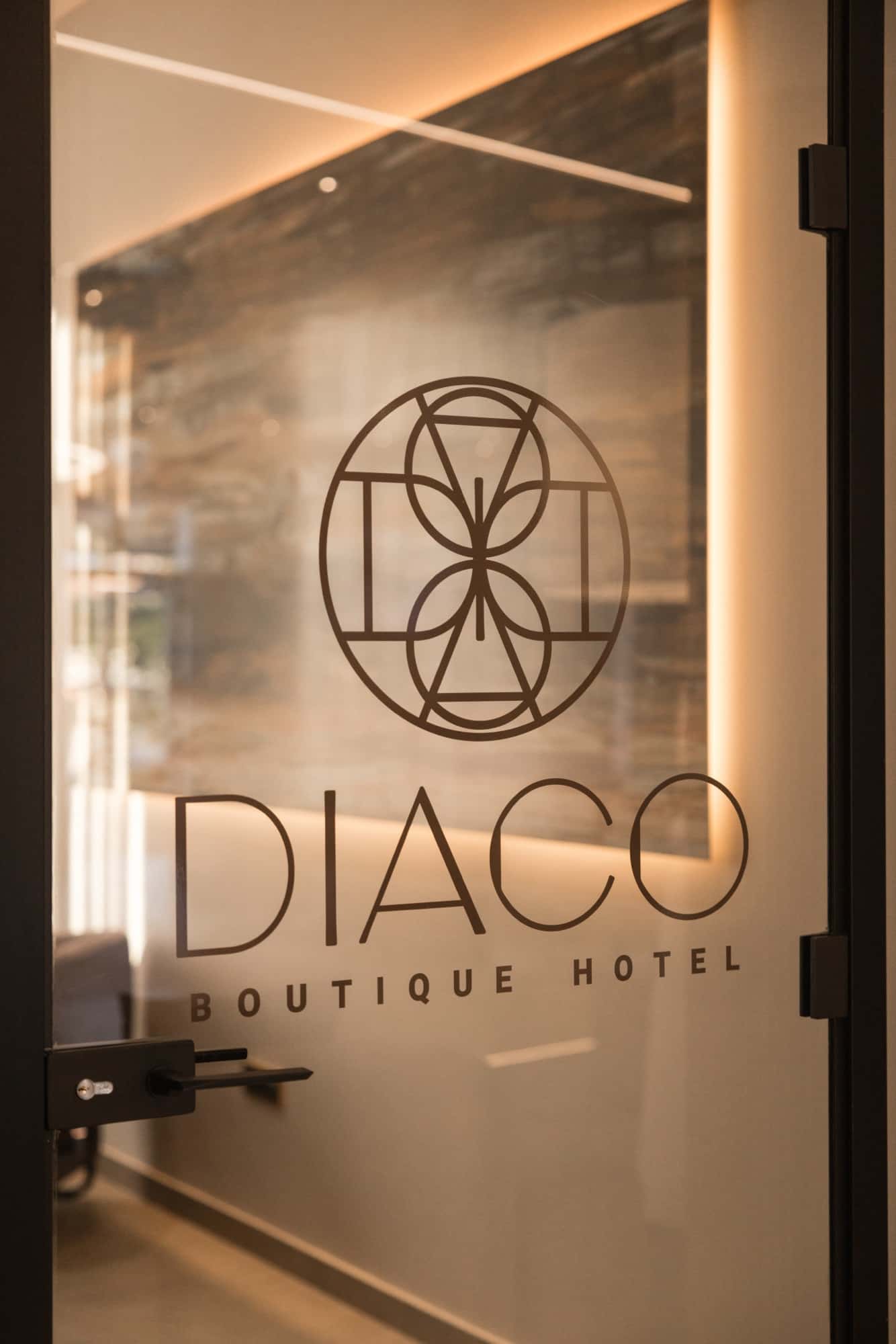 Logotip DIACO Boutique Hotel na staklenim vratima