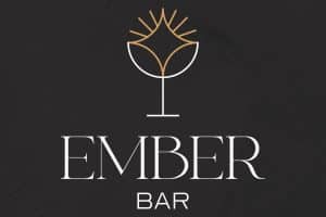 Logotip Ember Bar: bijela čaša sa zlatnom iskrom i naziv na tamnoj teksturi