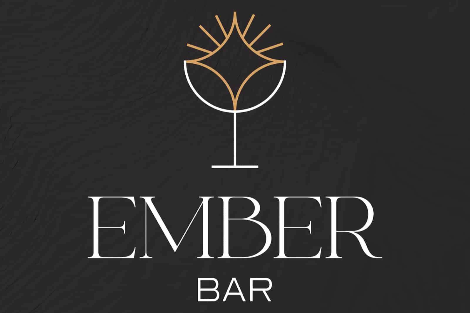 Logotip Ember Bar: bijela čaša sa zlatnom iskrom i naziv na tamnoj teksturi